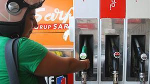 Una dona es disposa a posar gasolina a la seva moto.