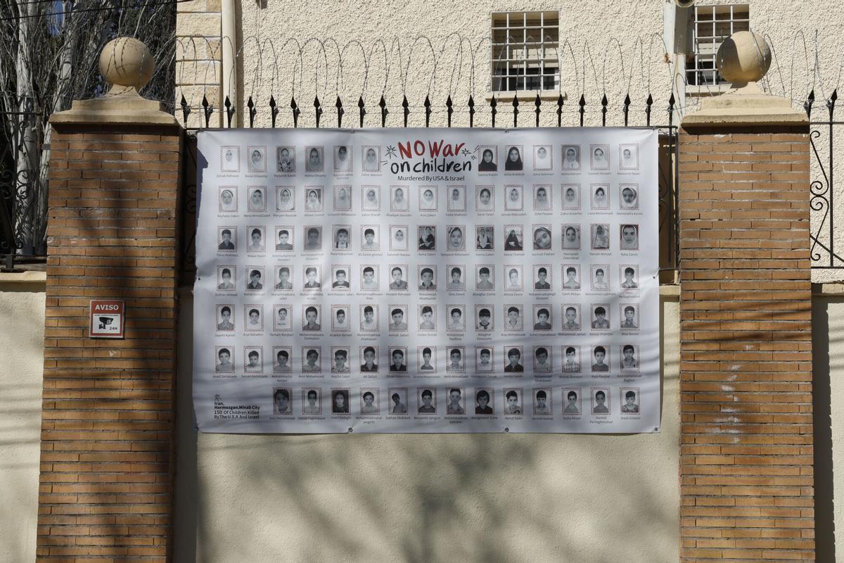 Vista del cartel con fotos de los niños asesinados en el ataque a una escuela iraní, en la embajada de Irán en Madrid.