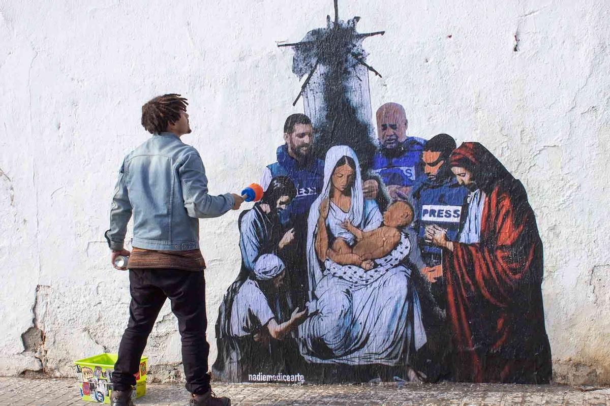 El artista Diego Ojeda pintando en Barcelona un mural que homenajea a los periodistas fallecidos en Gaza.