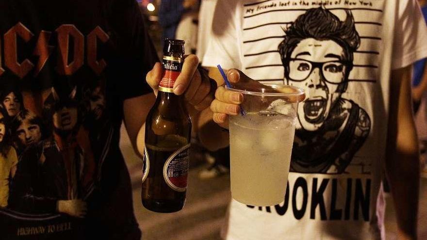 Dos jóvenes sujetan dos bebidas alcohólicas en un botellón de una noche en la ciudad. // Iñaki Osorio