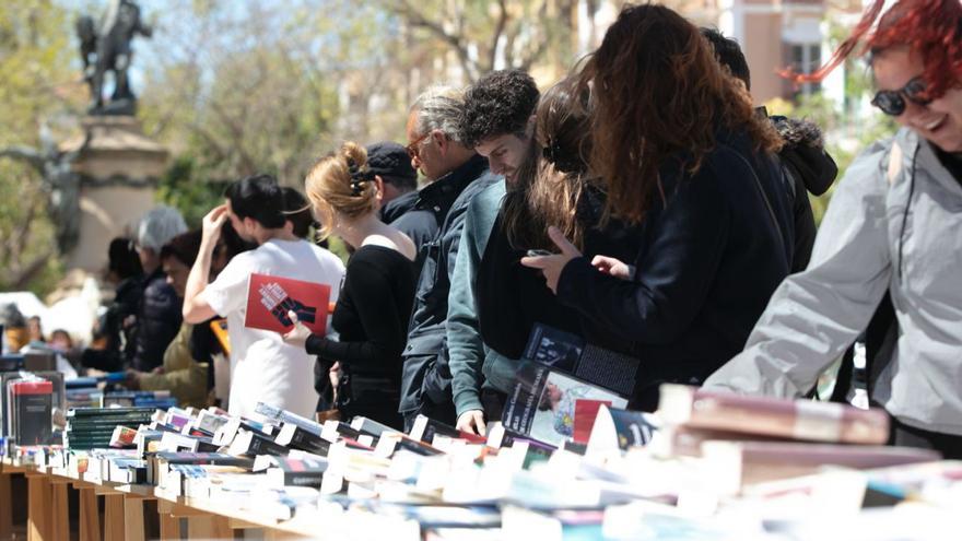 Varias personas miran los libros en uno de los puestos, el año pasado en el paseo de Vara de Rey. | VICENT MARÍ