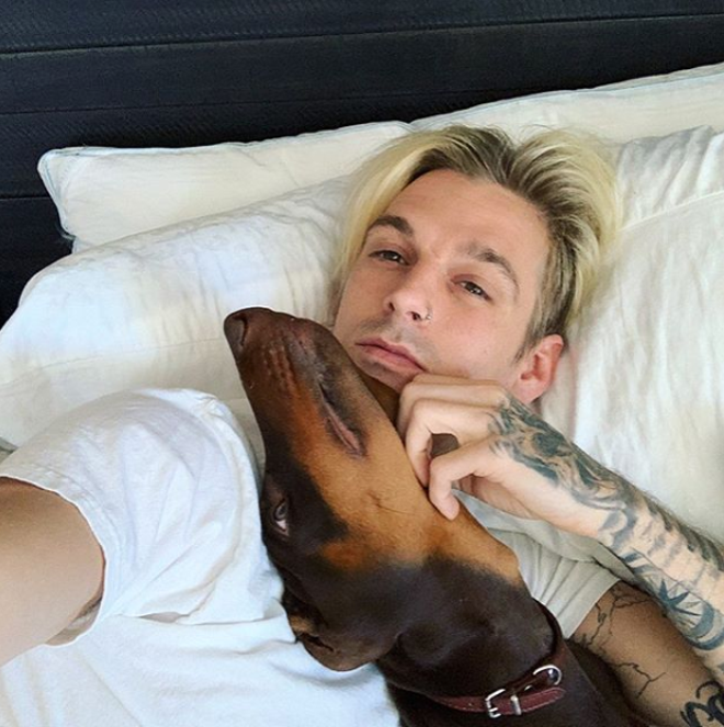 Aaron Carter con su perro en la cama