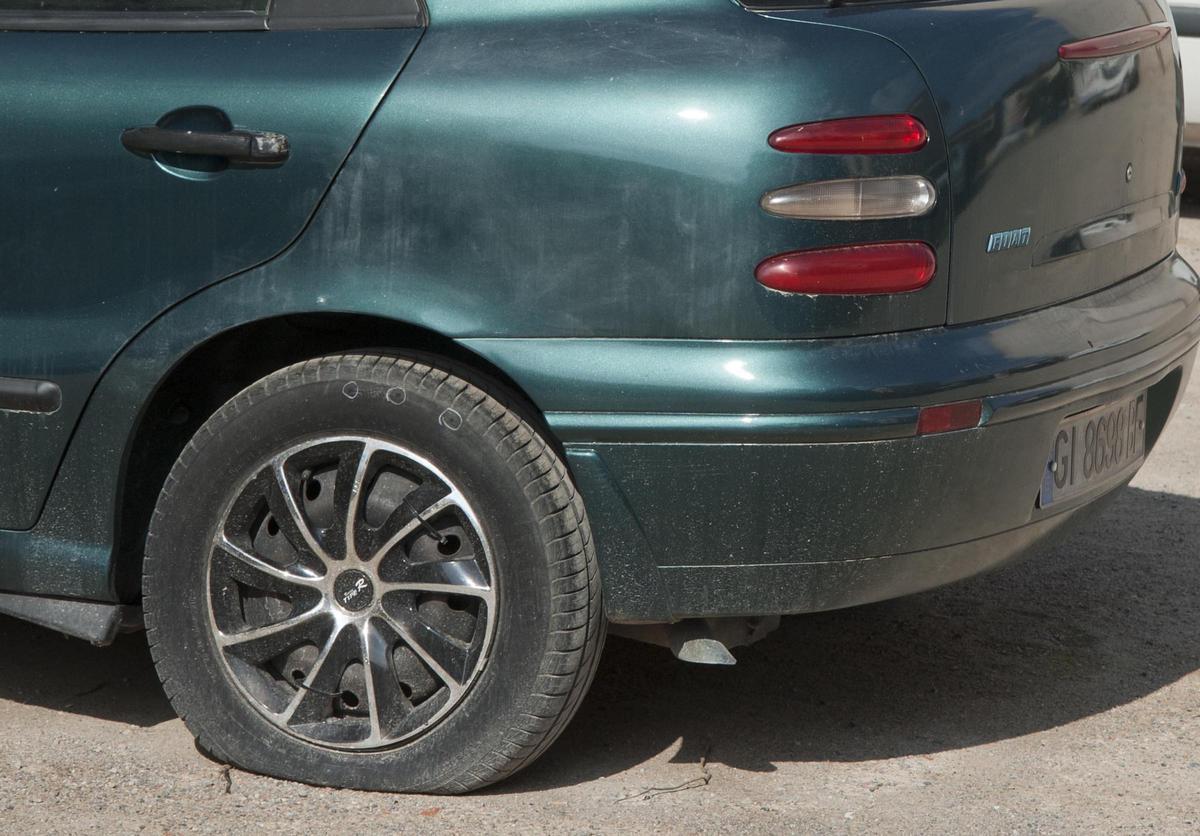 Imagen de archivo de una rueda de coche pinchada.