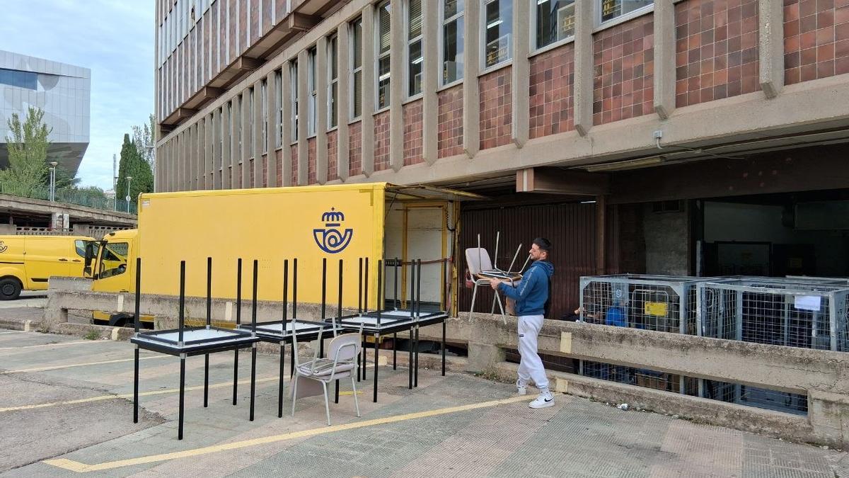 Un grupo de trabajadores en las tareas de desalojo del edificio de Correos en el barrio del Portillo de Zaragoza.