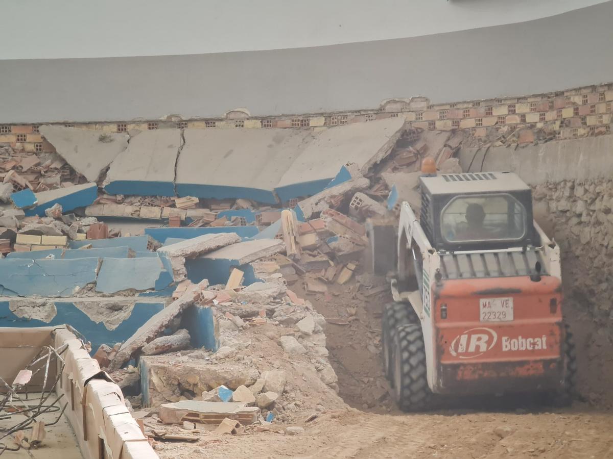 Una máquina trabajando en la demolición de las gradas.