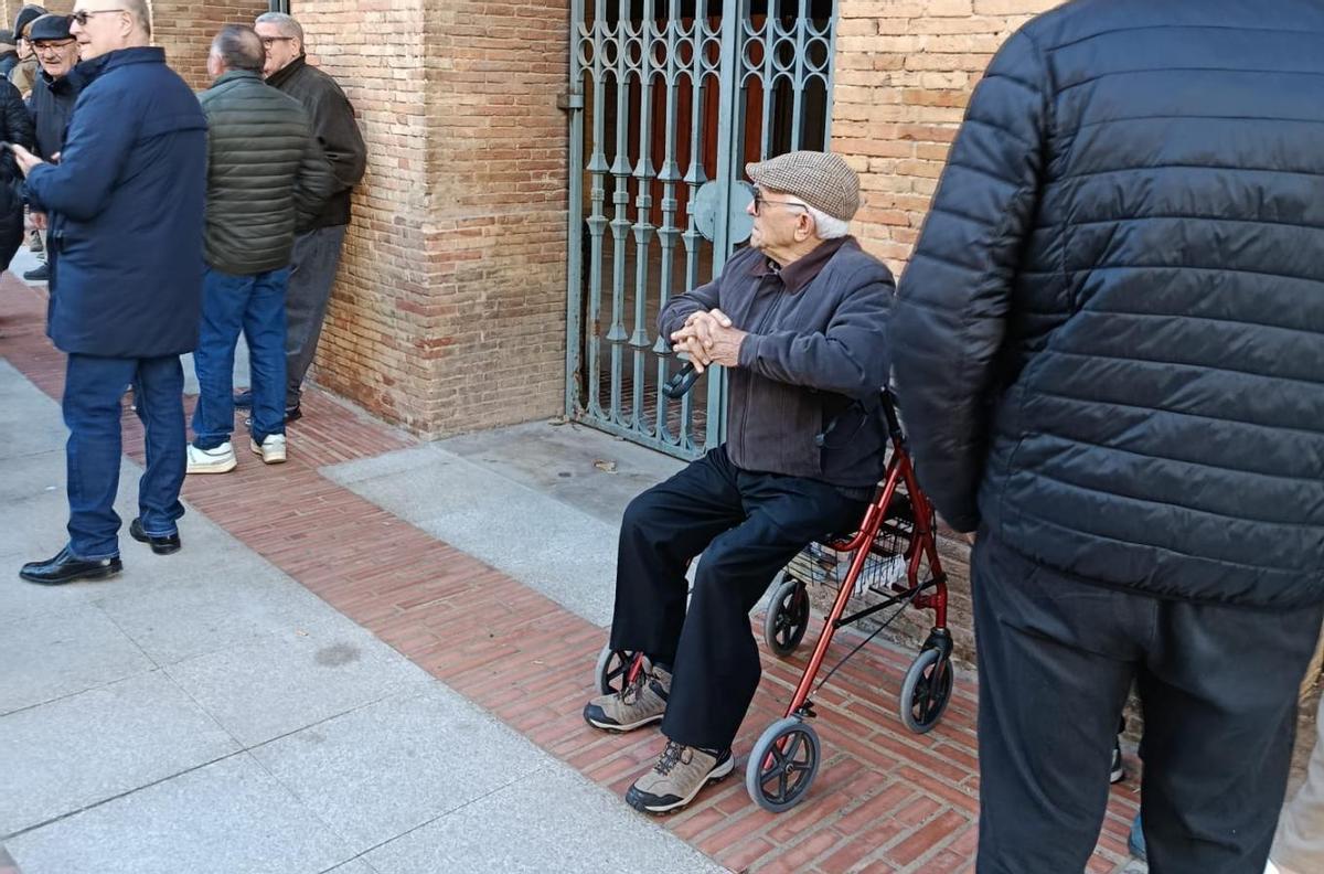 Una persona con dificultad para su movilidad hace cola en la plaza de València.