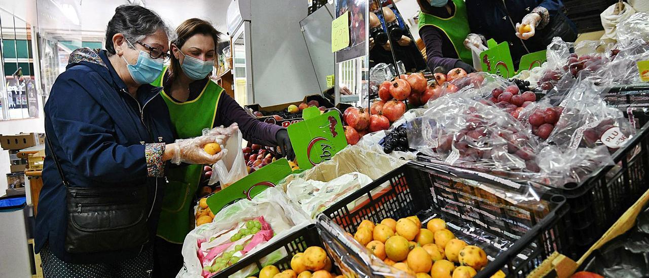 Sonia Miñán García atiende a una clienta en su frutería, que funciona desde hace 50 años en la calle San Antoniño.   | // GUSTAVO SANTOS