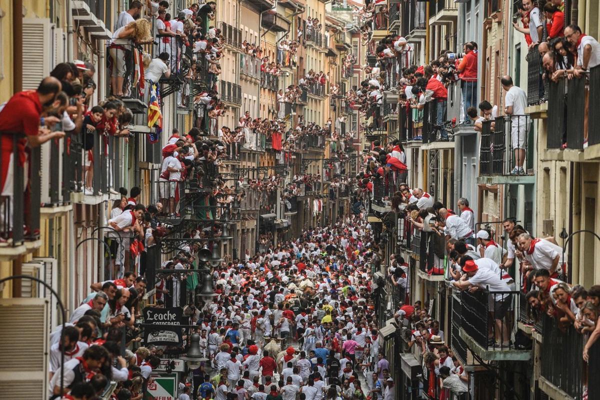 Balcones abarrotados de gente siguiendo el cuarto encierro de San Fermín, este domingo.