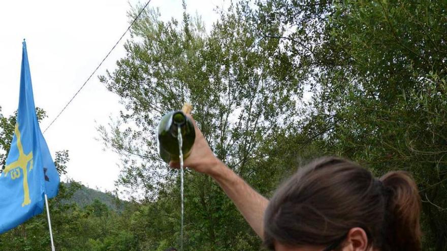 Un romero escancia sidra en la jira de Blimea.