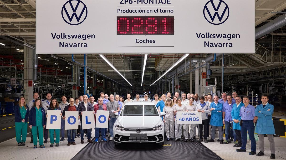 VW Navarra workers next to one of the Polo cars as it leaves the assembly line.