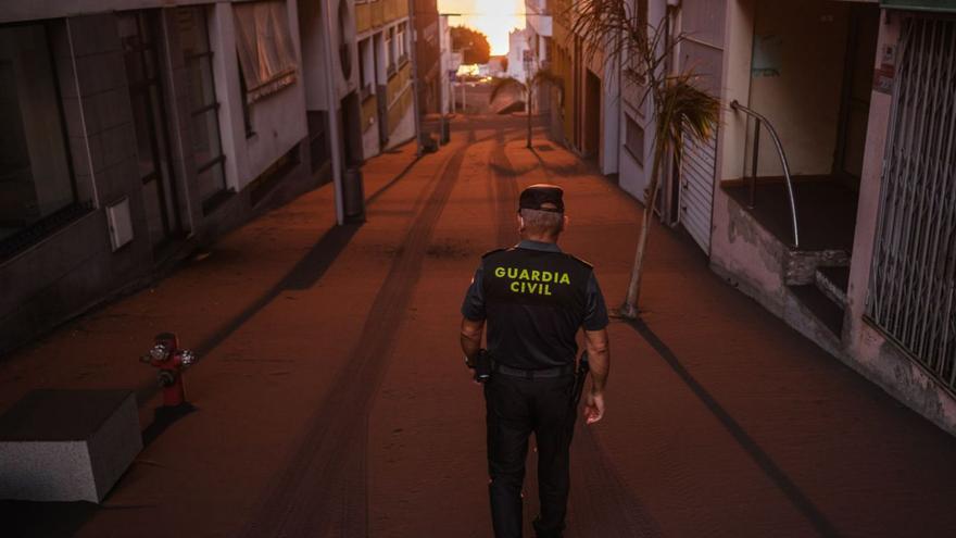 Un agente de la Guardia Civil camina por las calles de Puerto Naos cubiertas de ceniza en noviembre de 2021. | | ANDRÉS GUTIÉRREZ