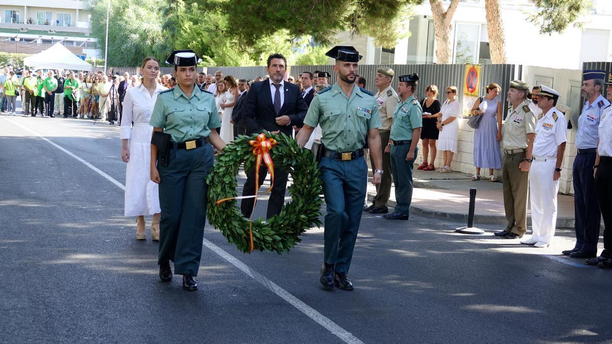 Marga Prohens und Juan Antonio Amengual hinter zwei Guardia-Civil-Beamten mit Blumenkranz.
