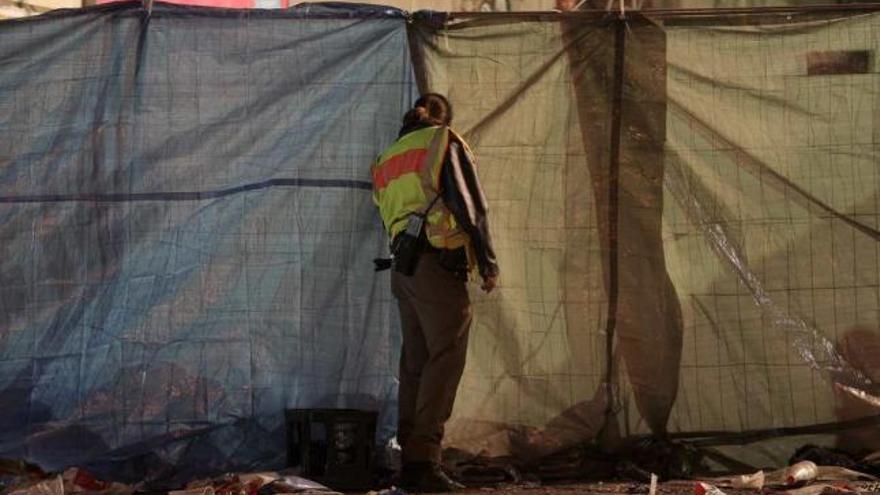 Un bombero mira por un hueco de la lona que cubre el túnel de acceso al «Love Parade».