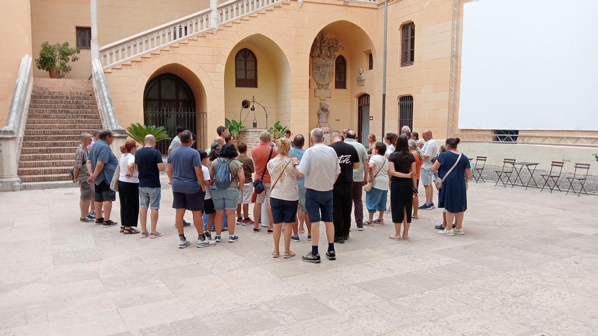 Turistas atienden al guia del Palau Ducal de Gandia antes de iniciar la visita, en una imagen de este viernes