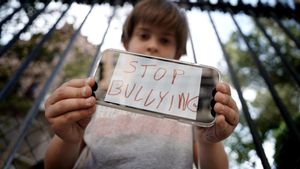 Un niño muestra en un móvil un cartel contra el acoso escolar, en un colegio de Madrid.