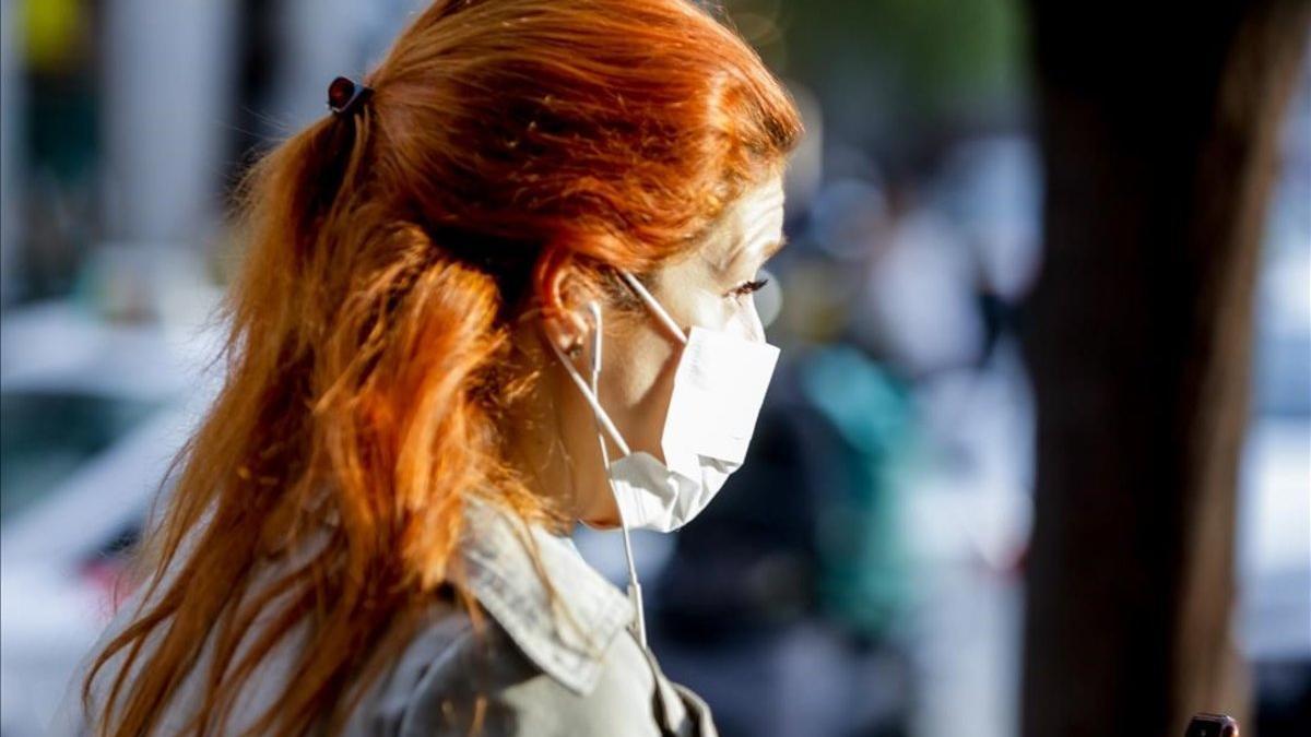 Una mujer con mascarilla por el riesgo de coronavirus en el centro de Madrid