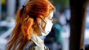 Imagen de archivo de una mujer con mascarilla por el riesgo de coronavirus.