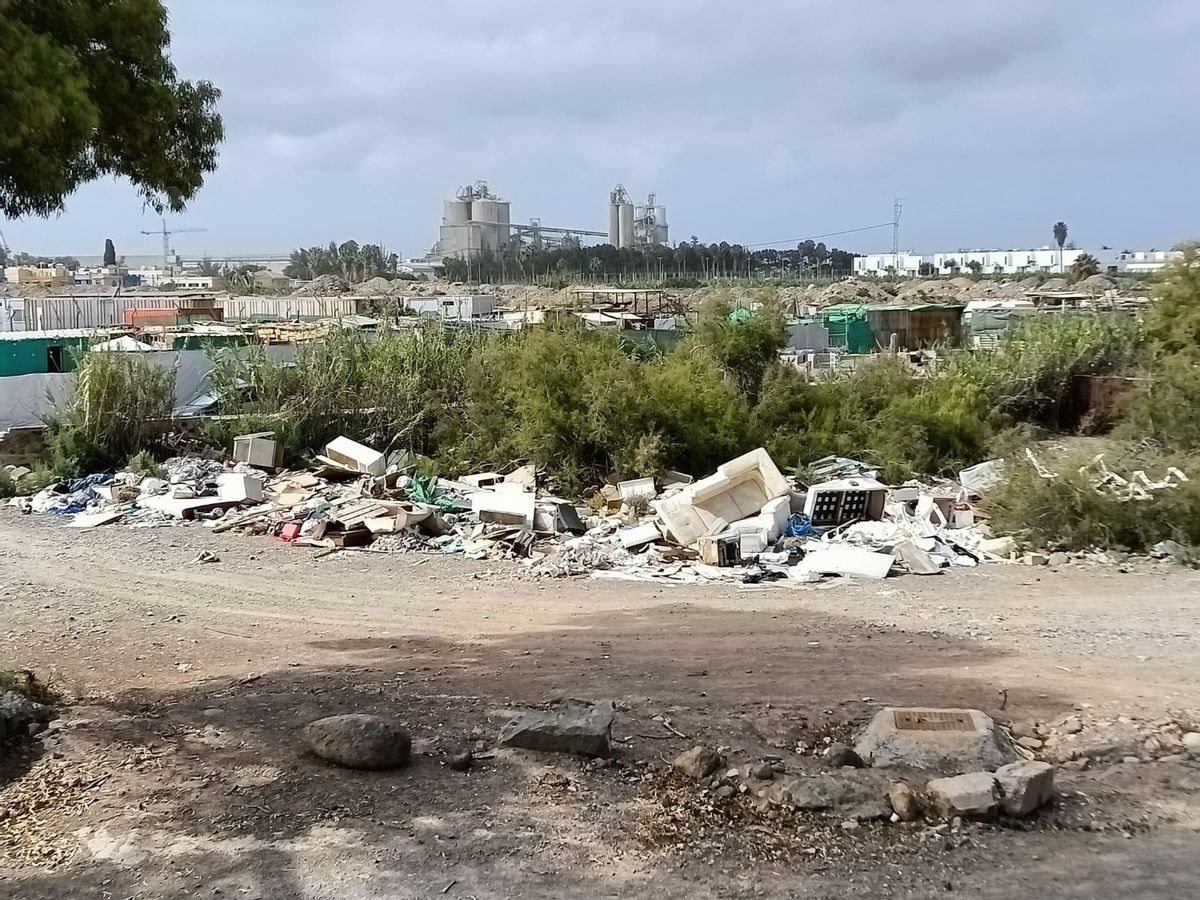 Uno de los focos de acumulación de residuos en el barranco de Arguineguín; detrás un asentamiento chabolista.