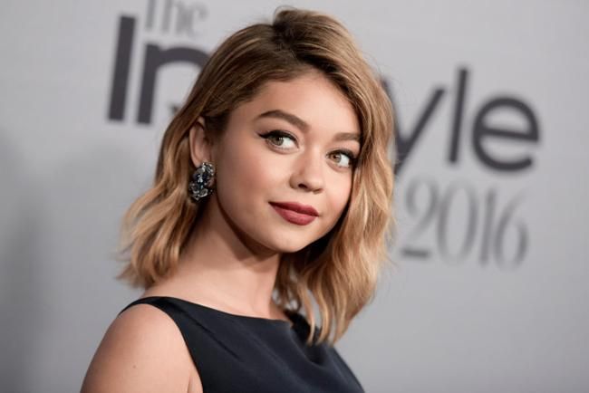 Sarah Hyland con vestido negro y labios granate
