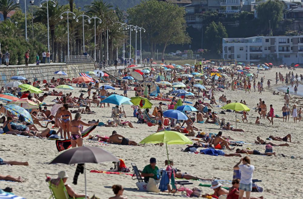 Bañistas disfrutando del buen tiempo en la playa de Samil. // Marta G. Brea