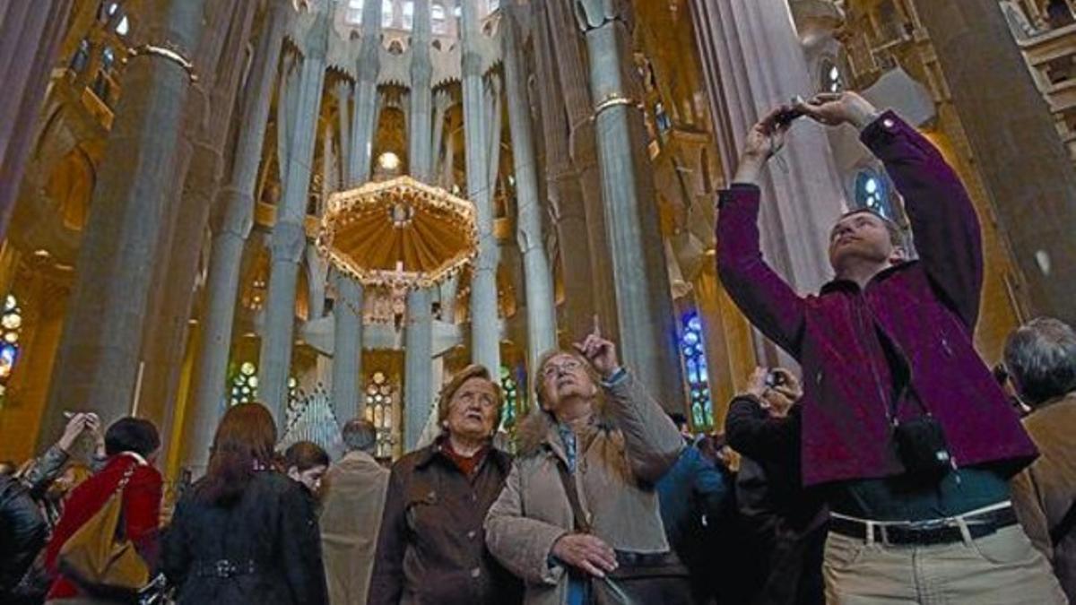 Varias personas comentan y fotografían el espectacular techo de la nave central de la Sagrada Família, el sábado pasado.