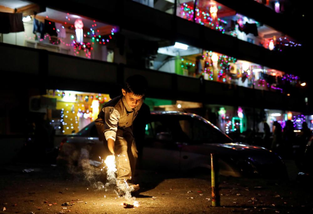 A boy lights a firecracker while celebrating the ...