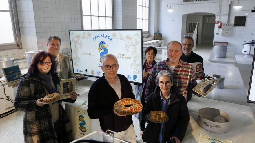 Por la izquierda, la bibliotecaria Chelo Veiga, Pablo Balbona, del Gremio de Artesanos Confiteros; Antón García, Carmen Moreno, de la Unión de Comerciantes; Esther Prieto, del Gremio de Editores; Ángel Luque, de la Asociación de Panaderos, y Rafa Gutiérrez, de la de Librerías, con libros y roscos en las antiguas cocinas de la Laboral. | MARCOS LEÓN