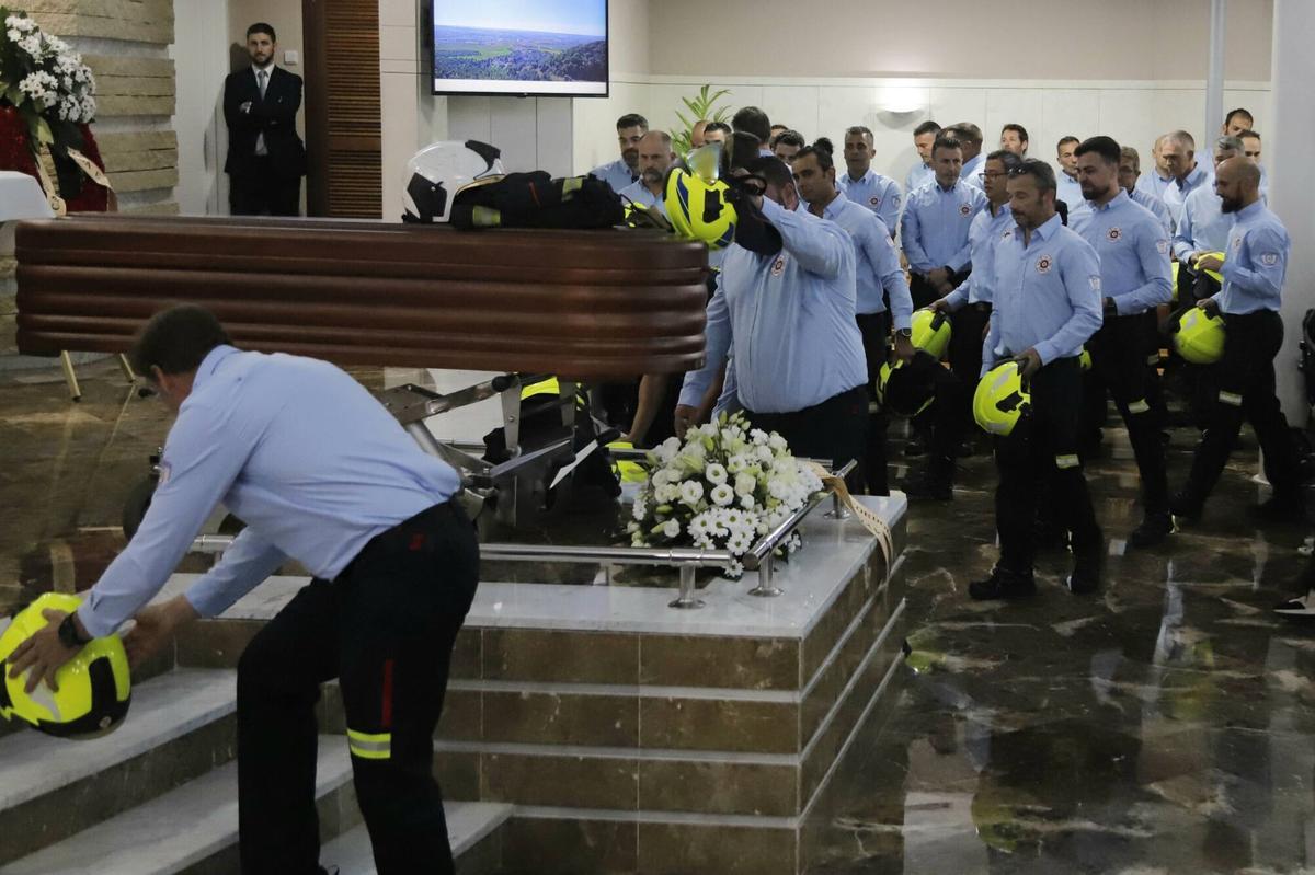 Los bomberos de Córdoba dejan sus cascos junto al féretro de su compañero fallecido de muerte súbita mientras practicaba ciclismo.