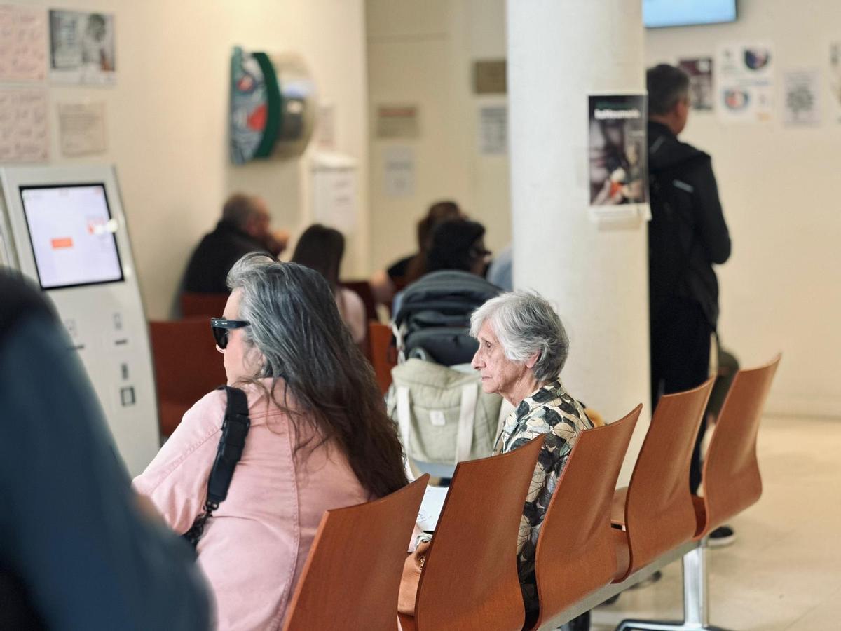 Dos pacientes esperan en el Centro de Salud San Luis, en Sevilla, a ser atendidos por su médico de cabecera el primer día de la tercera huelga médica en 2026.