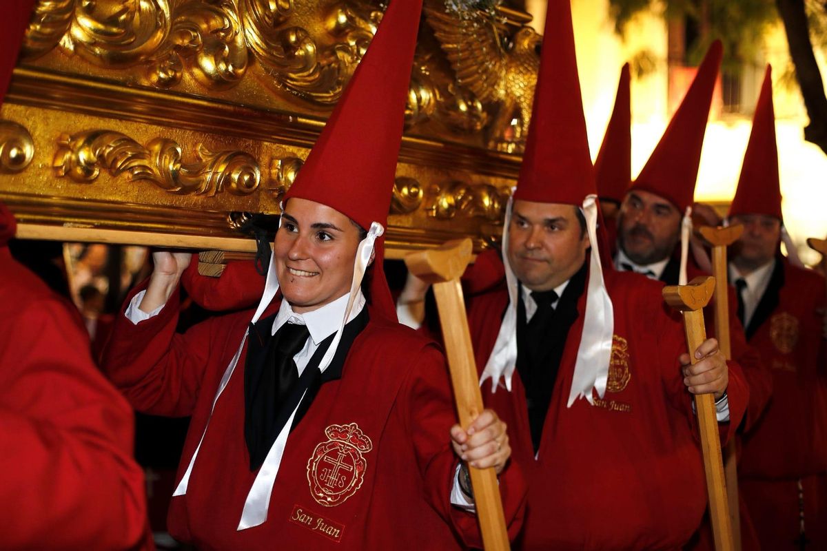 Haciendo historia: mujer y estante, llevando a hombros a San Juan, en la procesión de La Caridad, en Sábado de Pasión en Murcia.