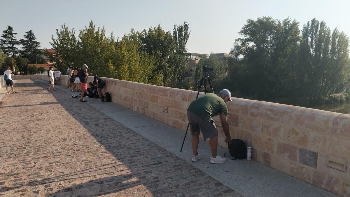 El fotógrafo Luis se prepara para fotografiar el eclipse desde el Puente de Piedra, usado como punto de observación por muchas personas