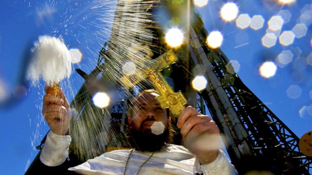 Un sacerdot ortodox beneeix la tripulació d’astronautes, davant la nau Soiouz TMA-19, programada per enlairar-se el 16 de juny des dels Estats Units.