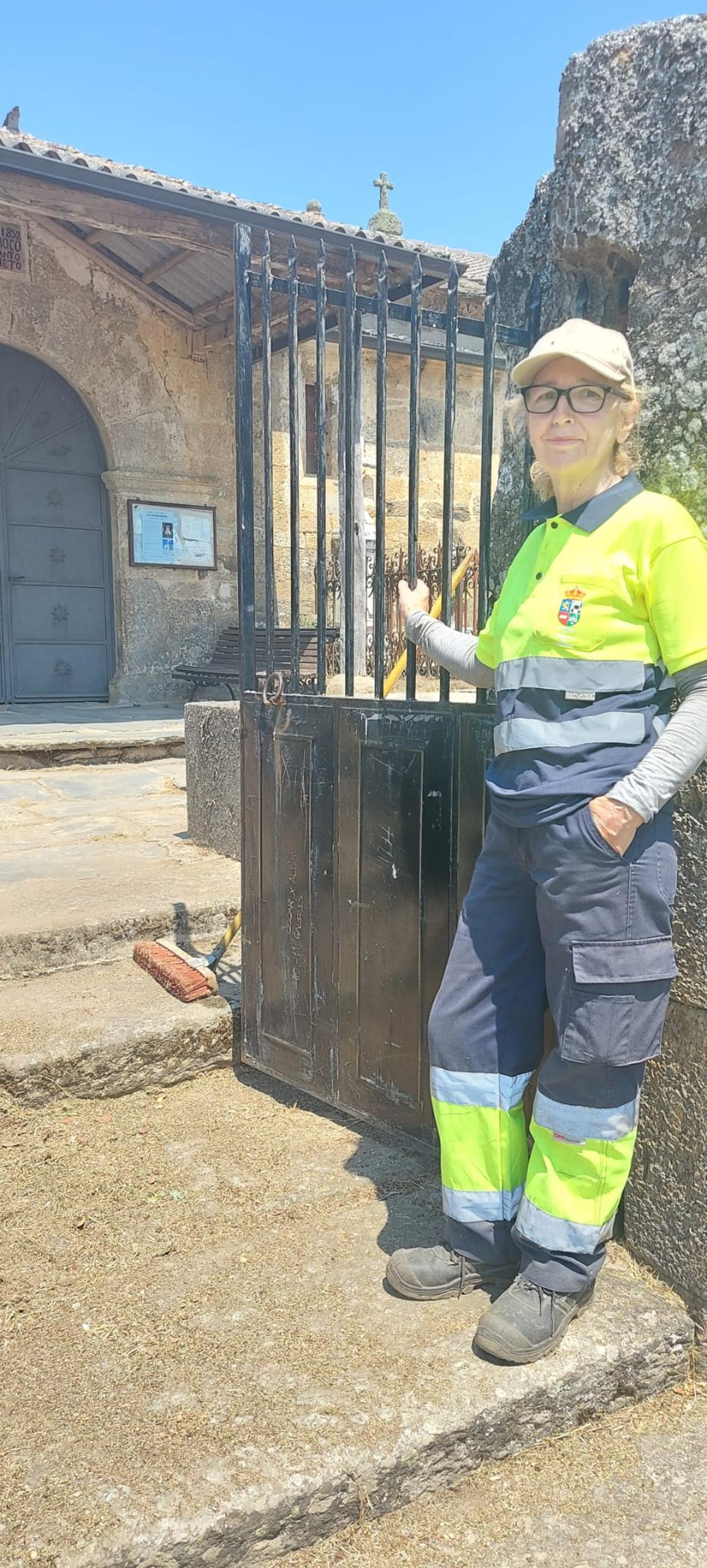 Carmen Lozano, operaria del Ayuntamiento, posa junto a la reja que da acceso a la iglesia y el cementerio de Gramedo.