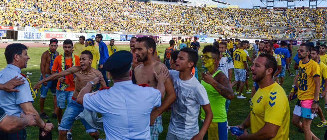 Varios jóvenes que saltaron al campo del Estadio de Gran Canaria en junio de 2014, cuando Las Palmas aspiraba a subir a Primera enfrentándose al Córdoba, se encaran con miembros de la seguridad privada.