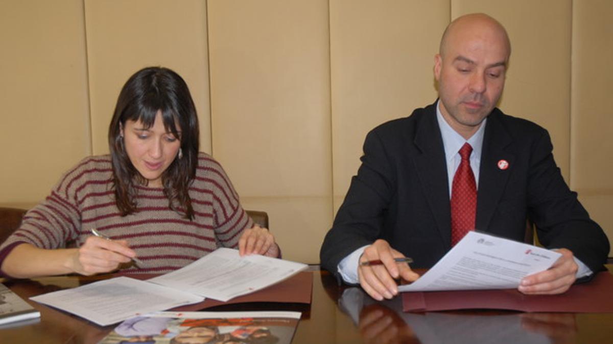 La alcaldesa, Núria Parlon, y el delegado de Save the Children en Catalunya, Antoni Pérez, en el momento de la firma del convenio.