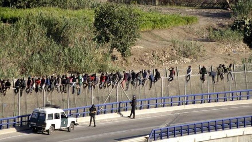 Medio centenar de inmigrantes permanecen encaramados en la valla de Melilla