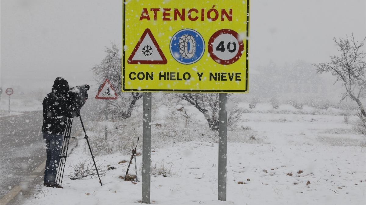 Un càmera de televisió grava l’estat d’una carretera durant una tempesta de neu. 