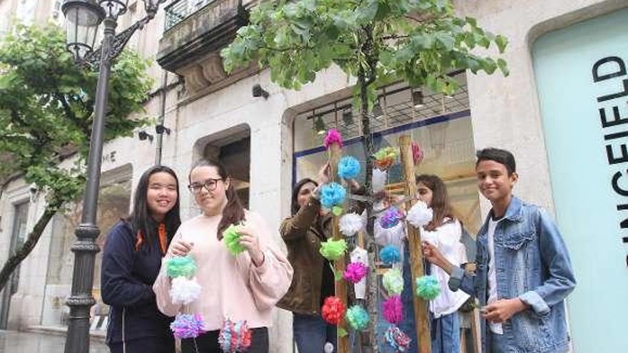 Los niños, engalanando un árbol en el paseo. // Iñaki Osorio