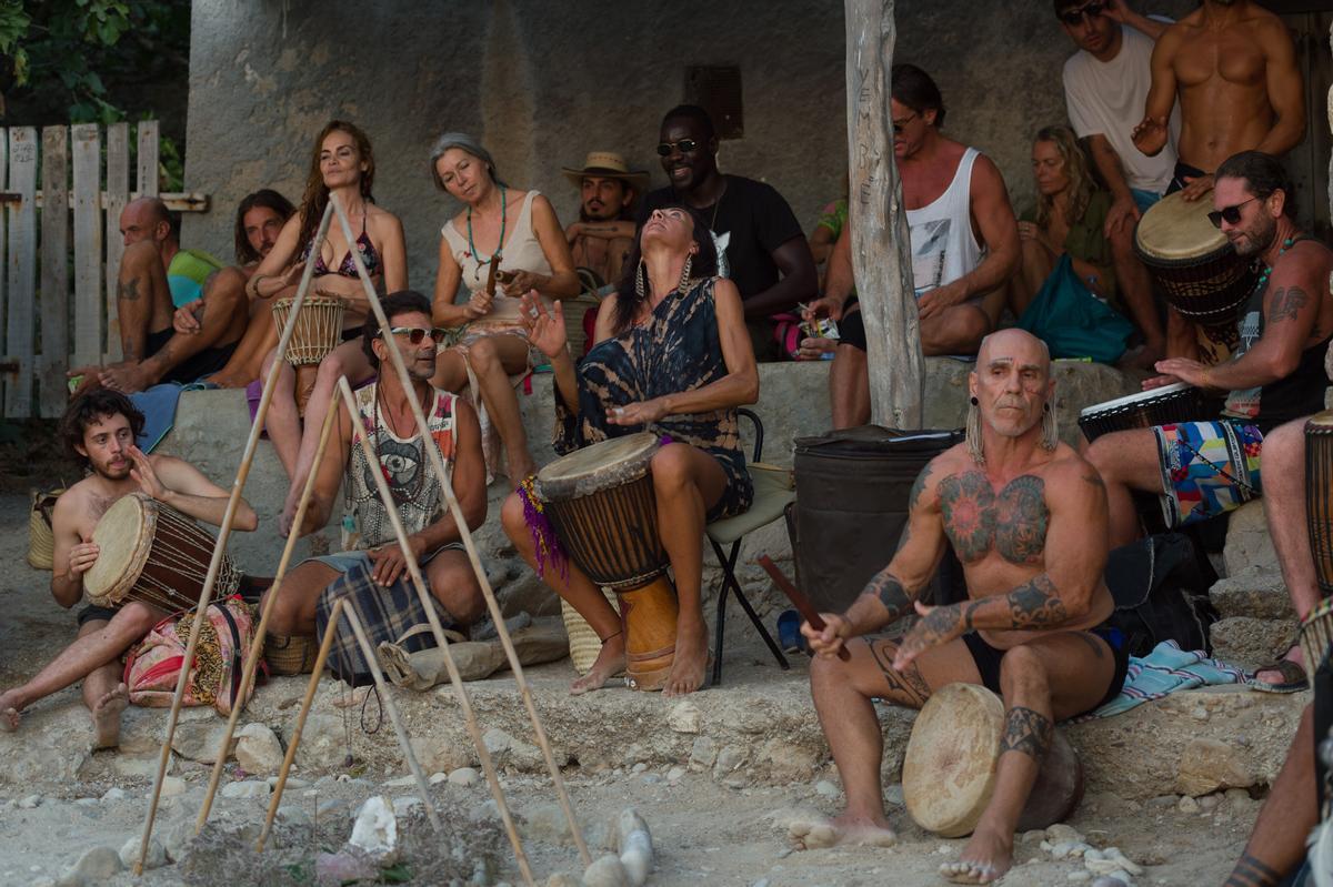 Un grupo de personas participan en la Fiesta de los Tambores en la Cala Benirrás