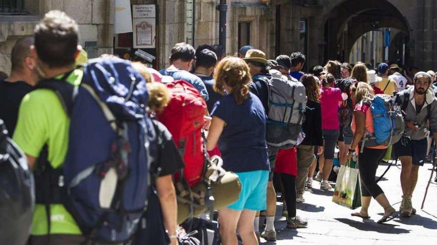 Un grupo de peregrinos hace cola en Santiago para obtener la Compostela.