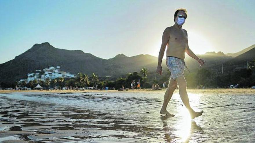 Un hombre camina a la orilla de la playa de Las Teresitas cumpliendo las medidas impuestas por el Gobierno autonómico .