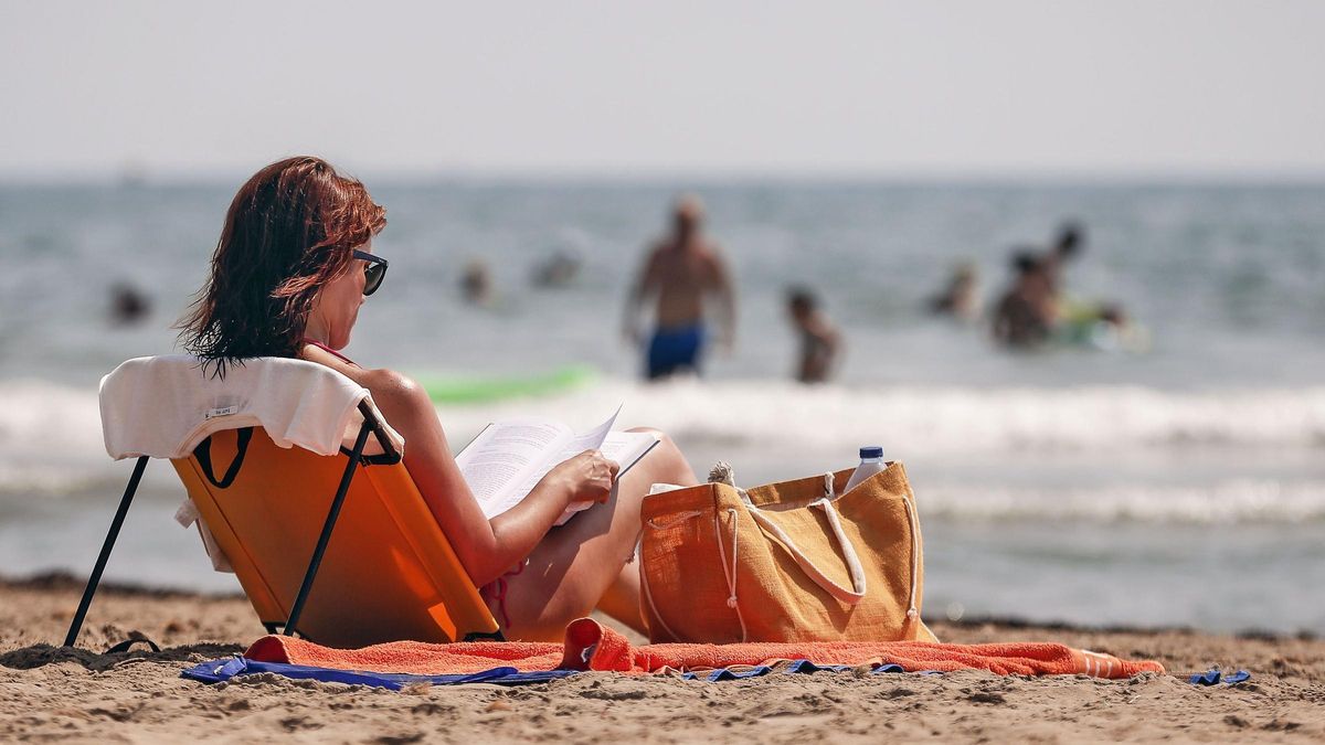 Una mujer leyendo en la playa.