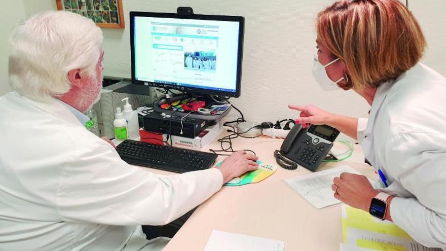 Los doctores Andrés Íñiguez y Marisol Bravo, con un ordenador para acceder a las teleconsultas. 