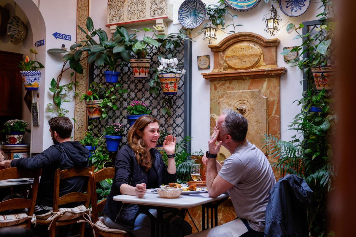 Una pareja comiendo en el patio de Taberna Salinas.