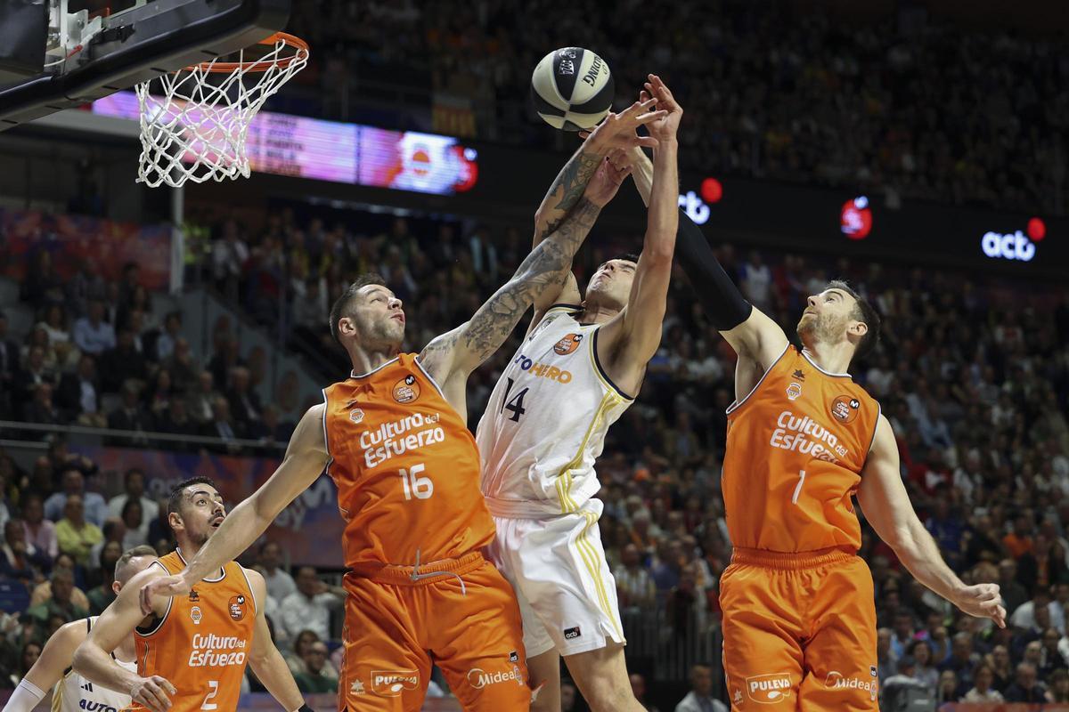 Stefan Jovic y Víctor Claver, en lucha por un rebote con Deck en el Real Madrid - Valencia Basket