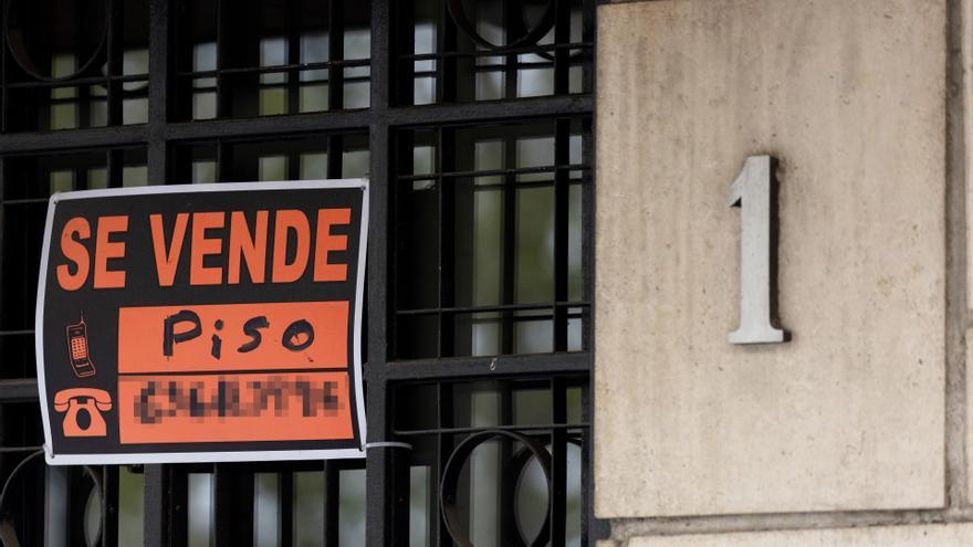 Vista de un cartel de 'Se vende' en un portal de un edificio.