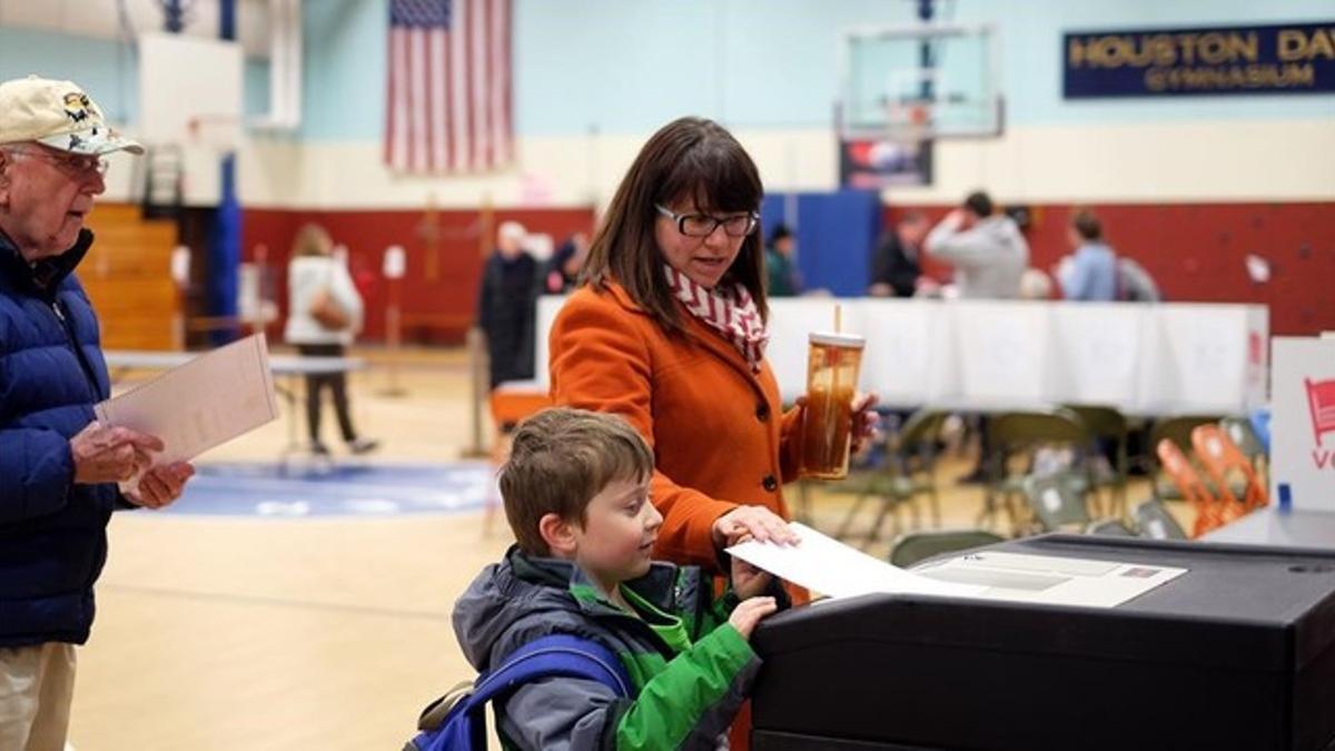 Una mujer con su hijo vota en las primarias en un gimnasio escolar de Concord (Nuevo Hampshire), este martes.