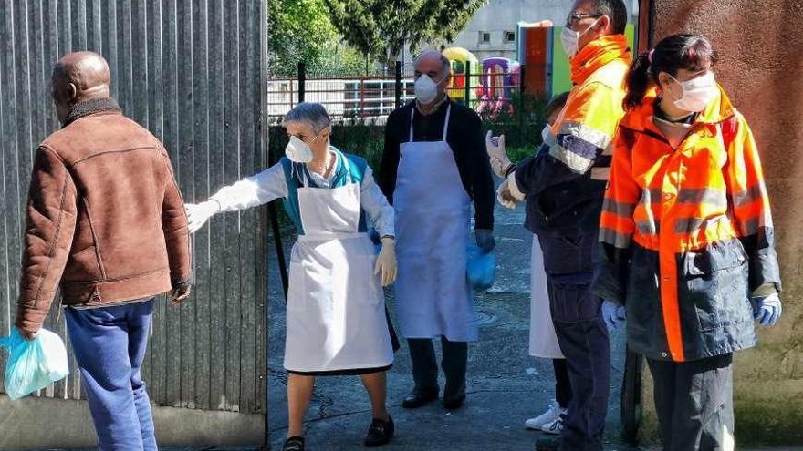 Entrega de paquetes de comida en el comedor social San Vicente de Paúl de Marín. // S.A.