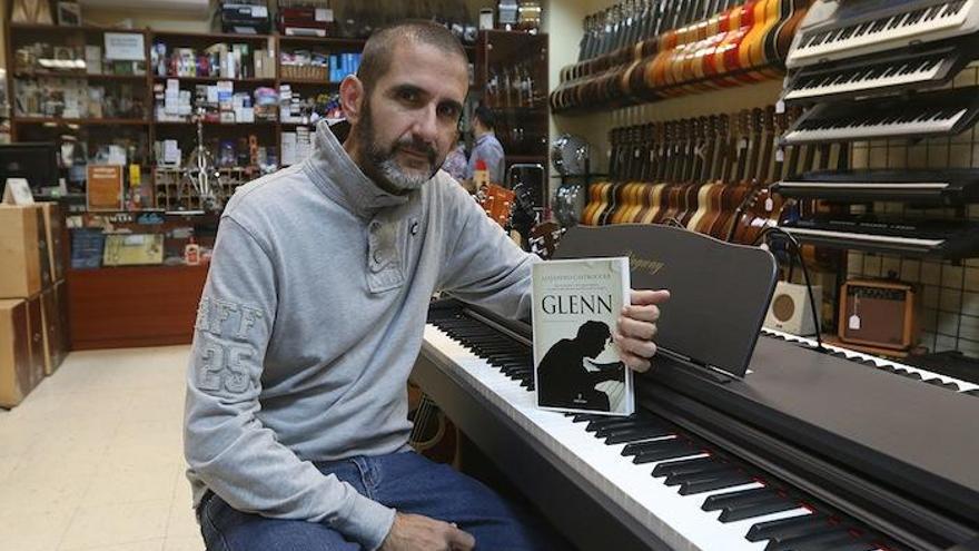 Alejandro Castroguer con su novela Glenn, en un piano de Málaga Musical en la calle Compañía.