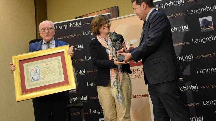 Carmen Antuña recibe el premio de manos de Rafael Velasco-Cadenas, director de Langrehotel, en presencia de Florentino Martínez Roces.